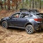 A Man Driving a Black Compact SUV on a Dirt Road