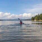 Person on Kayak Under Blue and White Sky