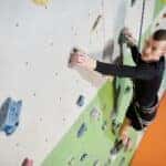 Man in Black Long Sleeve Shirt and Black Pants Climbing on Wall