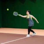 Woman playing pickleball in indoor court