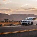 A white Subaru WRX on a desert road