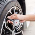 Oconomowoc, WI mechanic checking the tire pressure on a vehicle