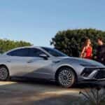 A couple standing beside a silver 2026 Hyundai Sonata sedan