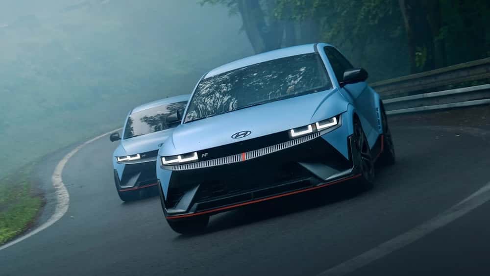 Two light blue 2026 Hyundai Ioniq 5 N sedans driving down a misty road