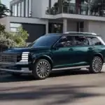 A dark green 2027 Hyundai Palisade SUV parked at a curb outside a house