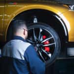 Professional inspecting brakes on Acura MDX