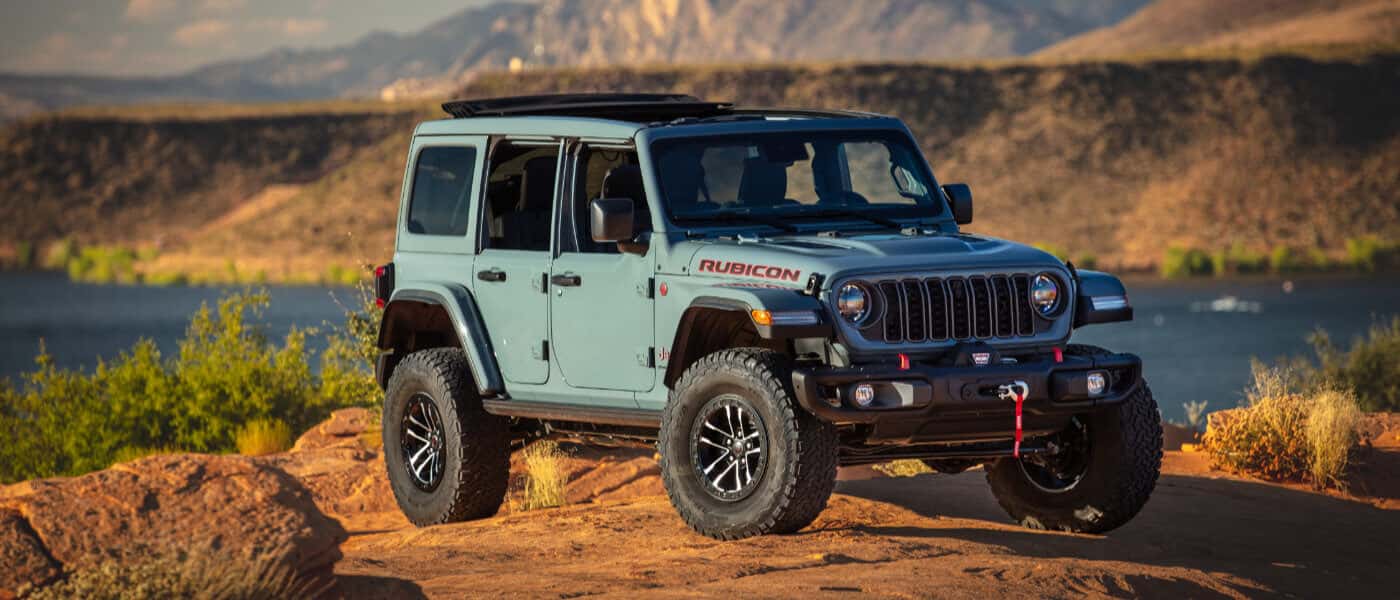 2026 Jeep Wrangler parked on lakeside rocks