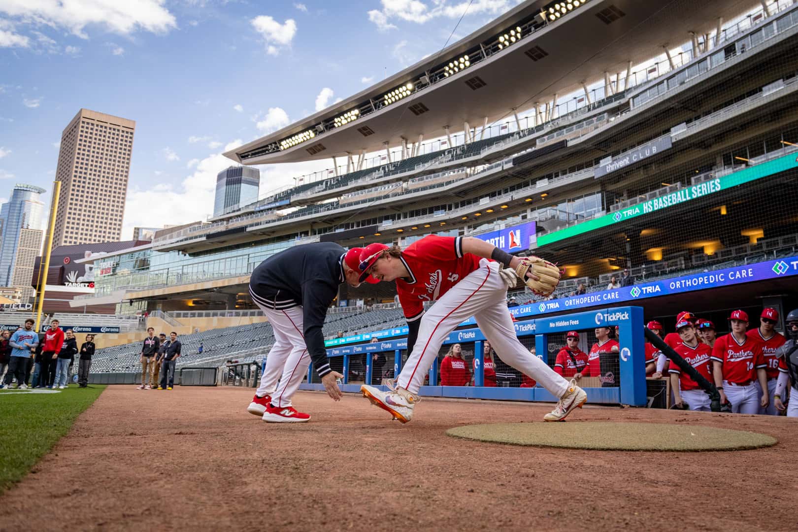 Coach and player high five as the starting lineup is announced at Target Field