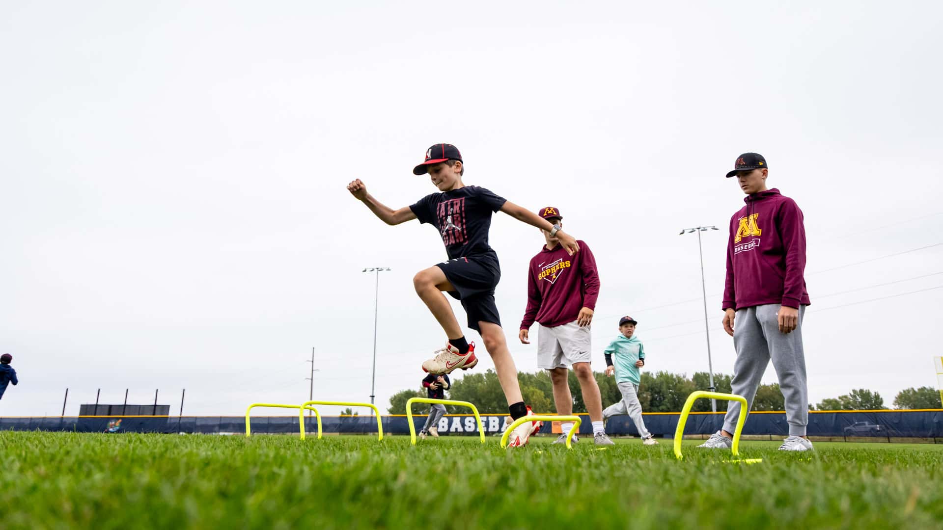 Young athletes participating in agility drills during the Gopher Baseball Youth Clinic
