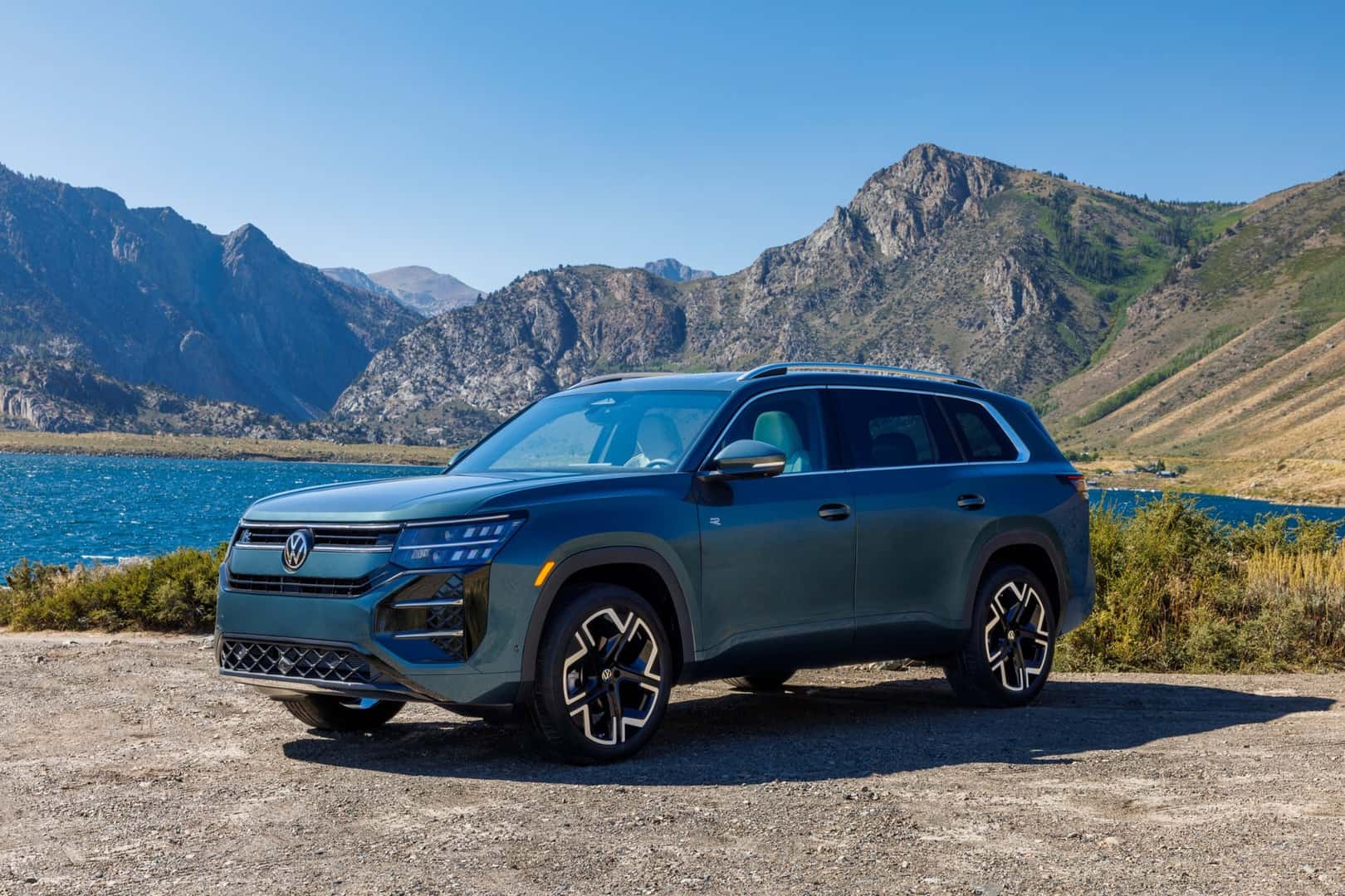 Front three-quarter view of the 2027 Volkswagen Atlas SEL R-Line beside a mountain lake