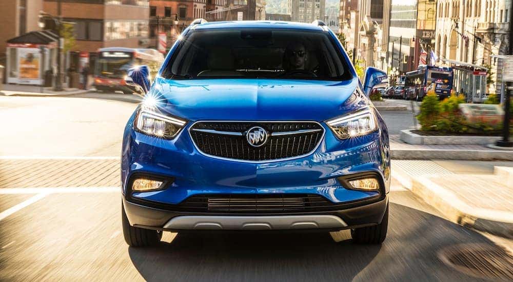 A blue 2018 Buick Encore is shown driving on a street after visiting a used Buick dealer in Atlanta.
