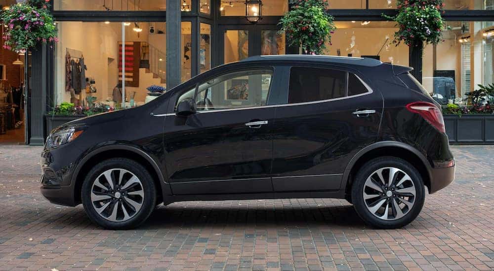 A black 2022 Buick Encore is shown parked near a shop.