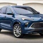 A blue 2024 Buick Encore GX is shown parked on a driveway near a Buick dealer in Atlanta.