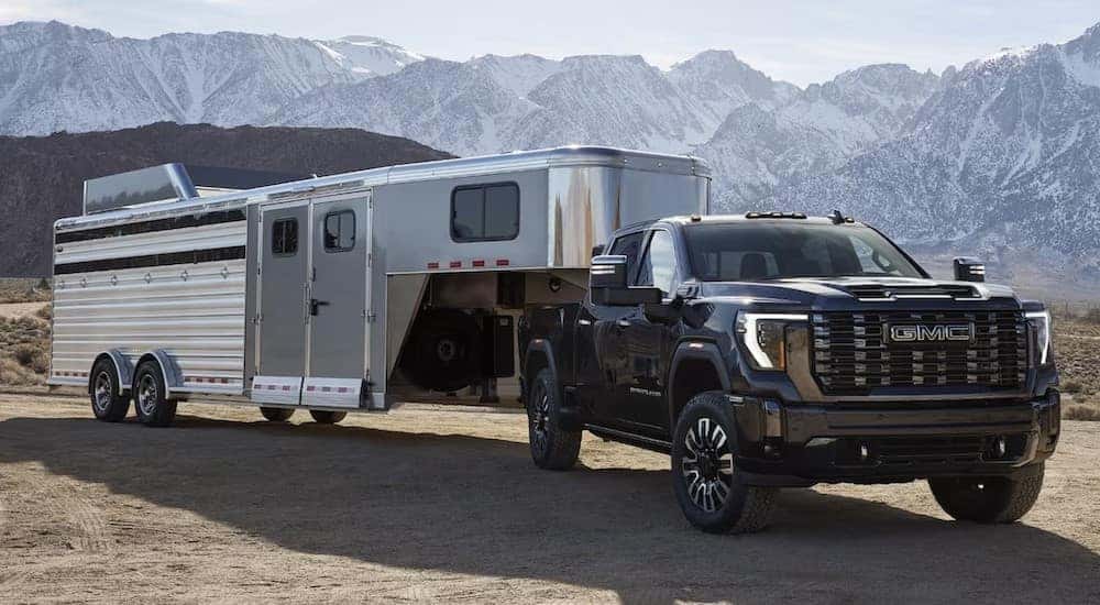 A black 2024 GMC Sierra 3500 HD is shown parked near mountains.