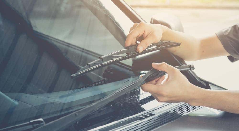 A person is shown fixing wiper blades at a GMC service center.