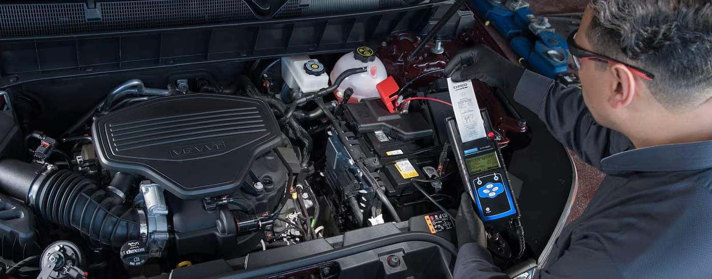 A GMC-Certified technician checking an engine's battery life.