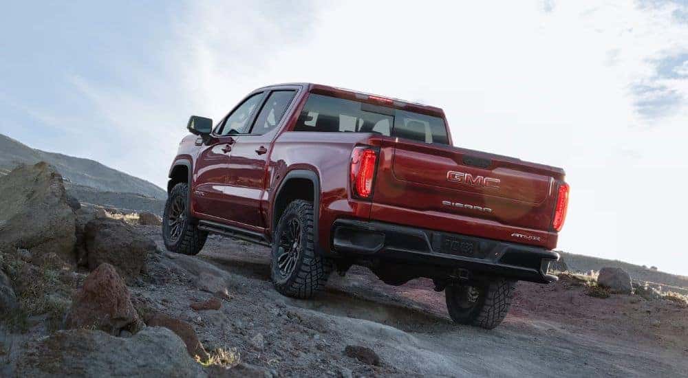 A red 2023 GMC Sierra 1500 AT4X is shown off-roading.