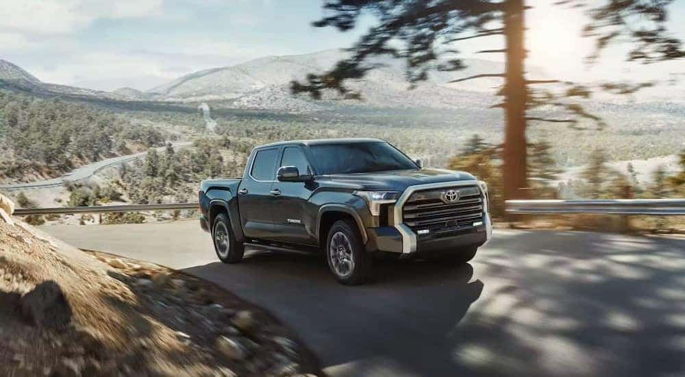 A gray 2023 Toyota Tundra is shown driving uphill.