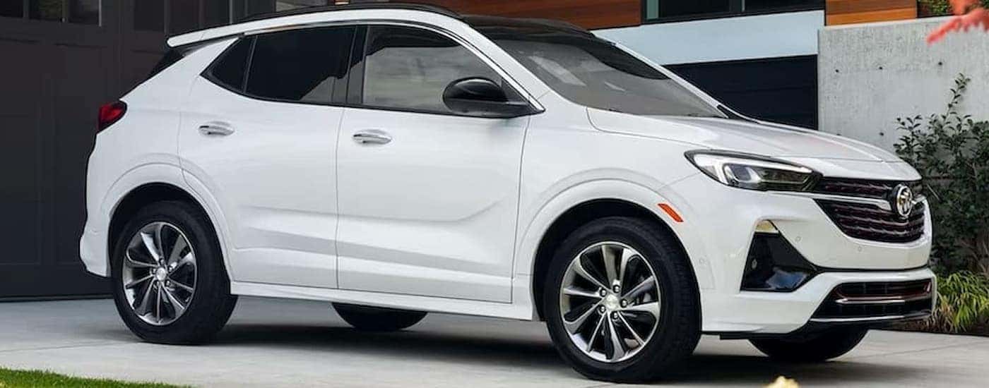A white 2023 Buick Encore GX is shown parked on a driveway after visiting a used car dealer.