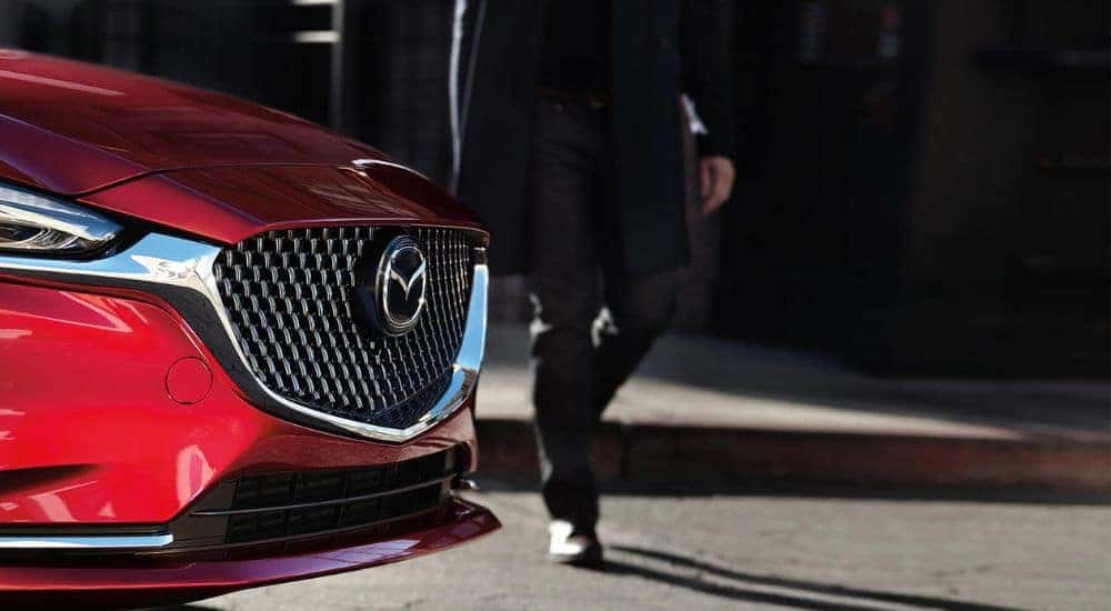 Close-up of the grille of a red 2019 Mazda6 at a used car dealer.