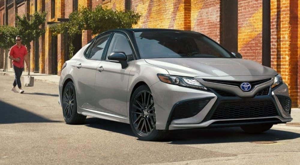 A silver 2022 Toyota Camry XSE Hybrid parked on a city street.