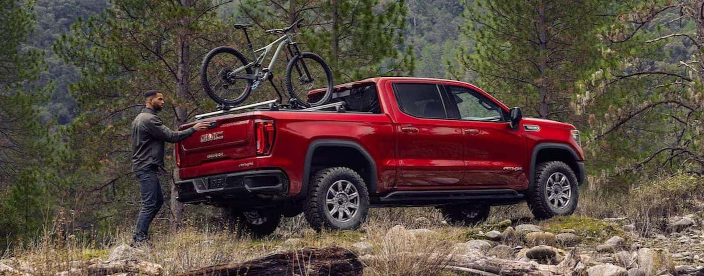 A red 2025 GMC Sierra 1500 AT4X is shown parked after viewing lifted GMC trucks.