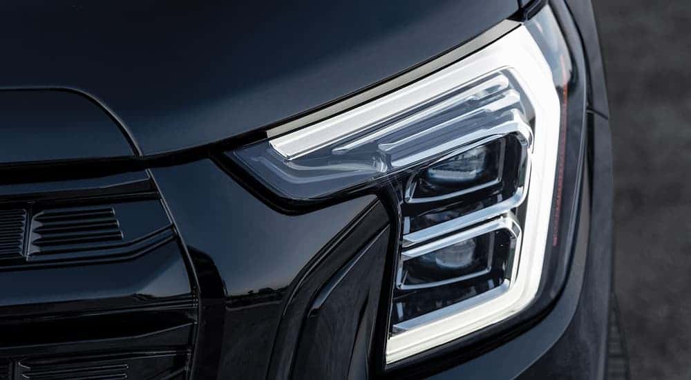 Close-up on the headlight of a black 2025 GMC Terrain.
