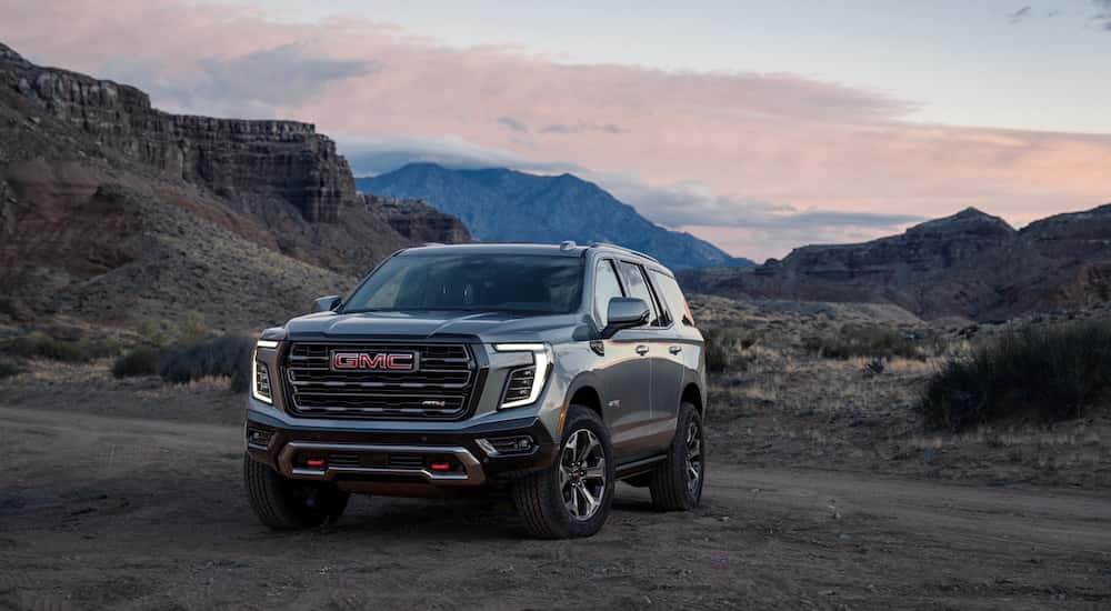 A grey 2025 GMC Yukon AT4 is shown from the front at an angle.