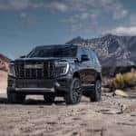 A black 2025 GMC Yukon Denali Ultimate is shown from the front at an angle.