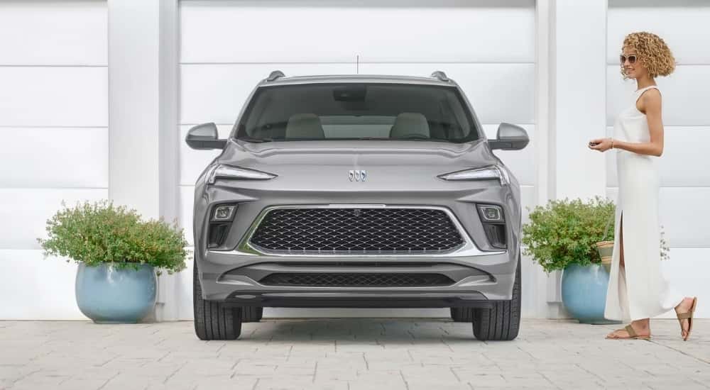 A grey 2025 Buick Encore GX Avenir is shown near plants.