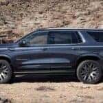 A blue 2025 GMC Yukon Denali parked off-road.