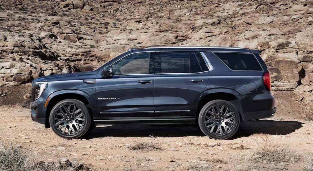 A blue 2025 GMC Yukon Denali parked off-road.
