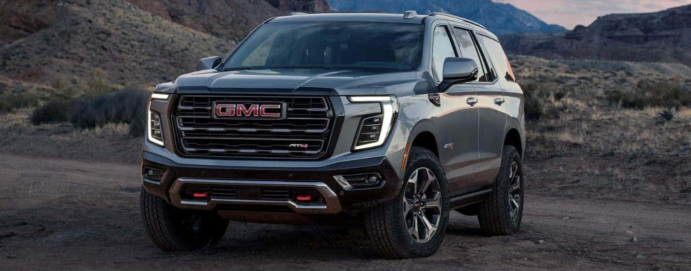 A grey 2025 GMC Yukon AT4 parked off-road.