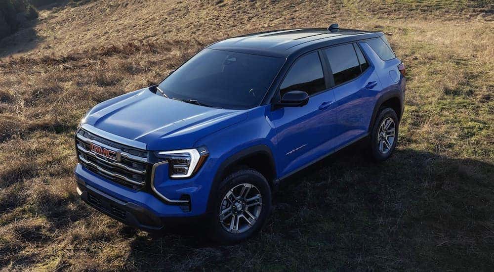 High view of a blue 2026 GMC Terrain Elevation parked on grass.
