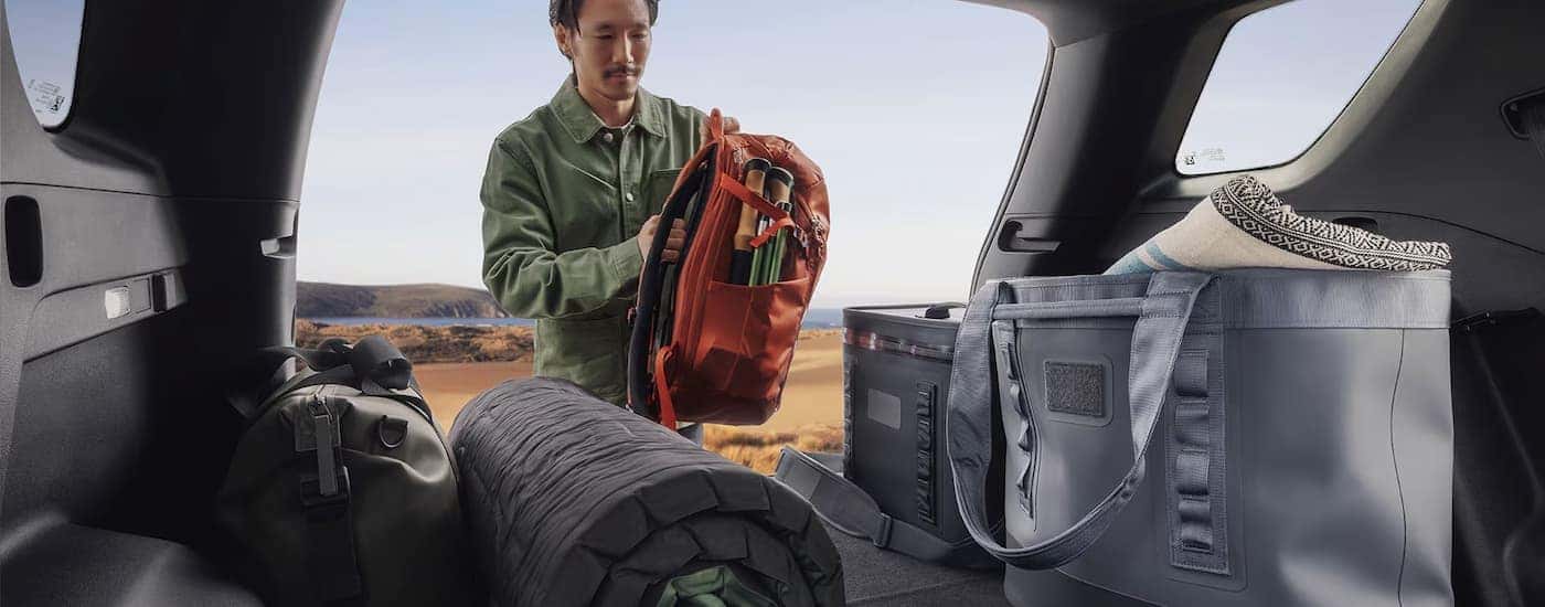 Man adding items to the cargo space of a 2025 GMC Terrain