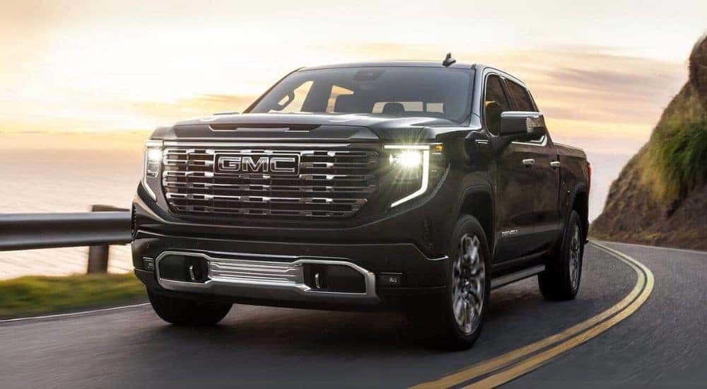 A black 2025 GMC Sierra 1500 Denali driving down a highway