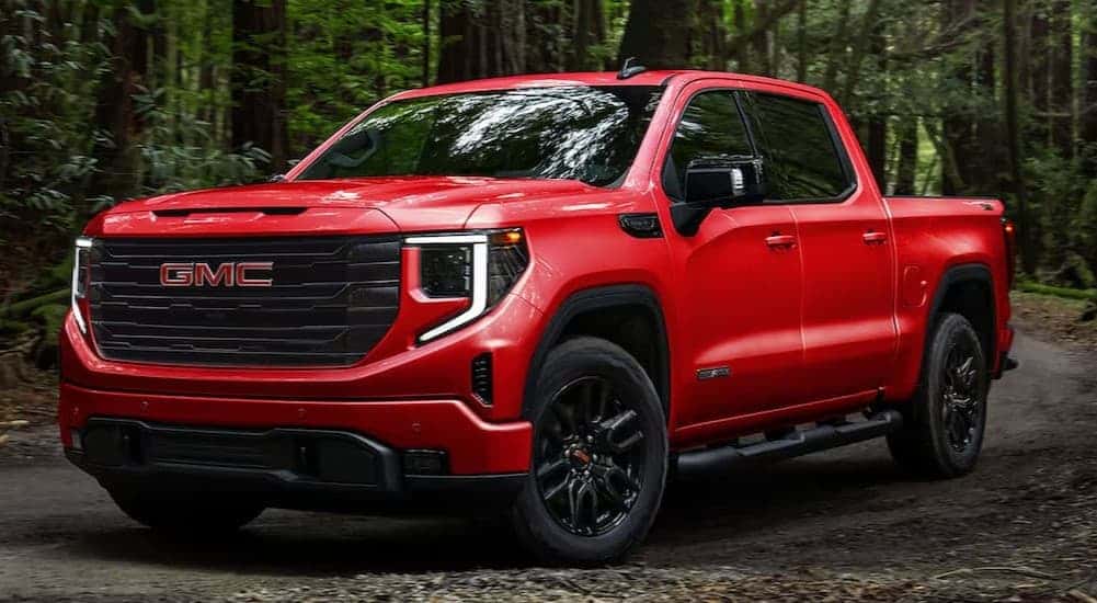 A red 2025 GMC Sierra 1500 Elevation parked on a dirt road.