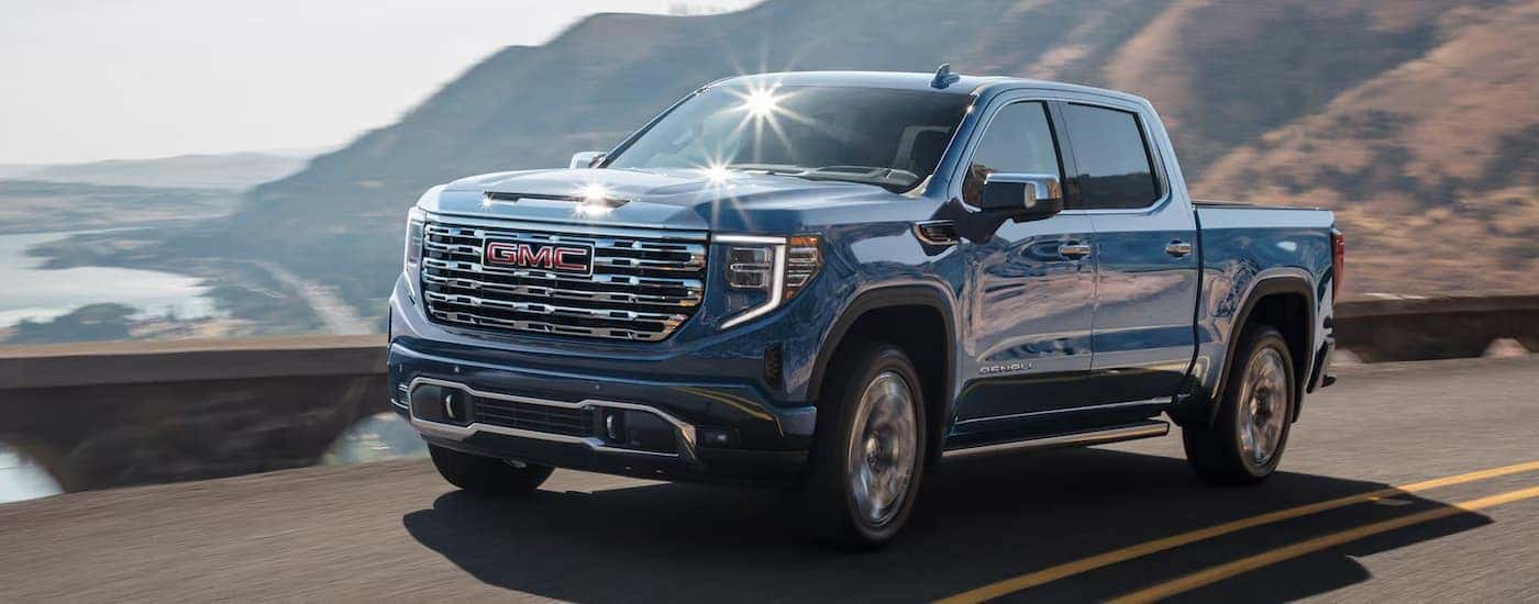 A blue 2025 GMC Sierra 1500 driving down a highway