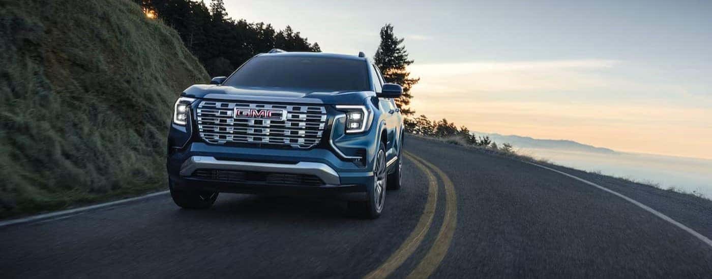A blue 2026 GMC Terrain driving on a highway.