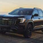 A black 2026 GMC Terrain driving on a trail.