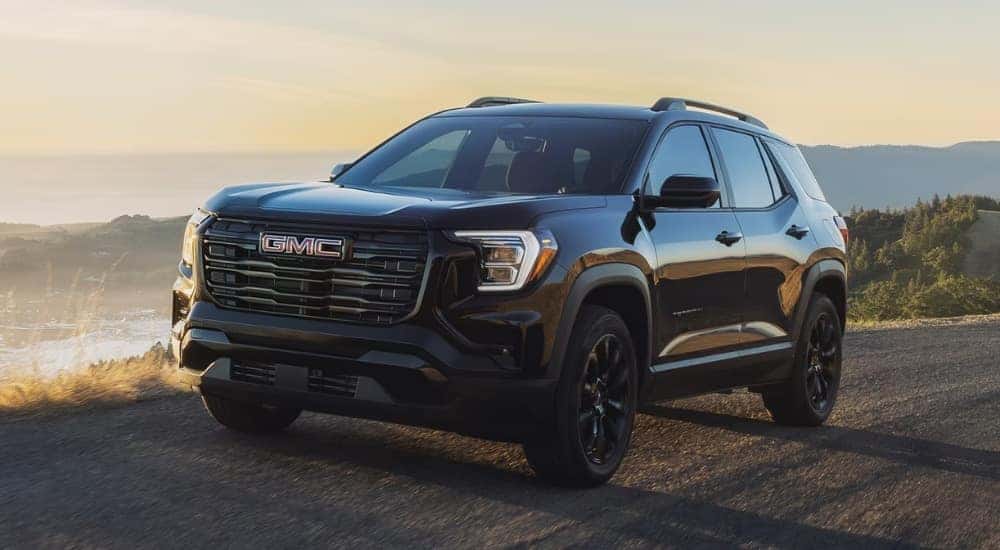A black 2026 GMC Terrain driving on a trail.