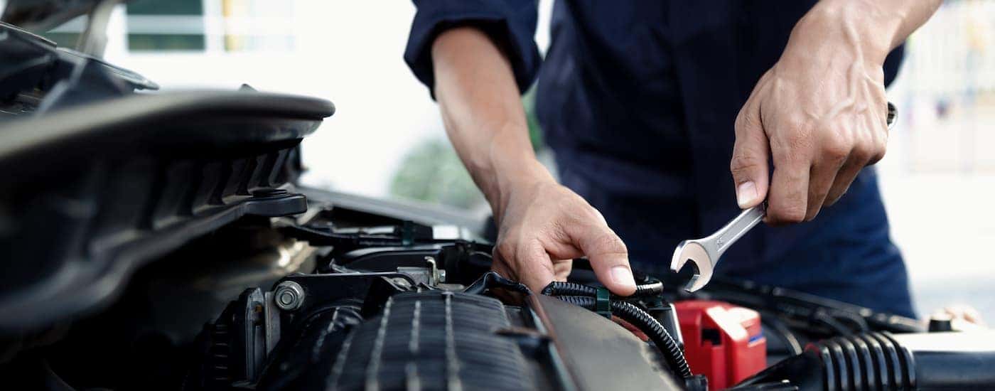 A mechanic working on the engine of a car at a GMC Service Center