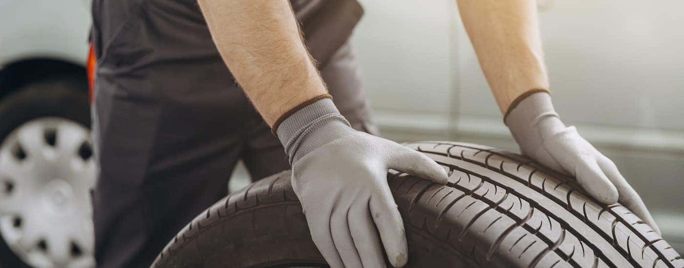 A person moving a tire at a GMC service center