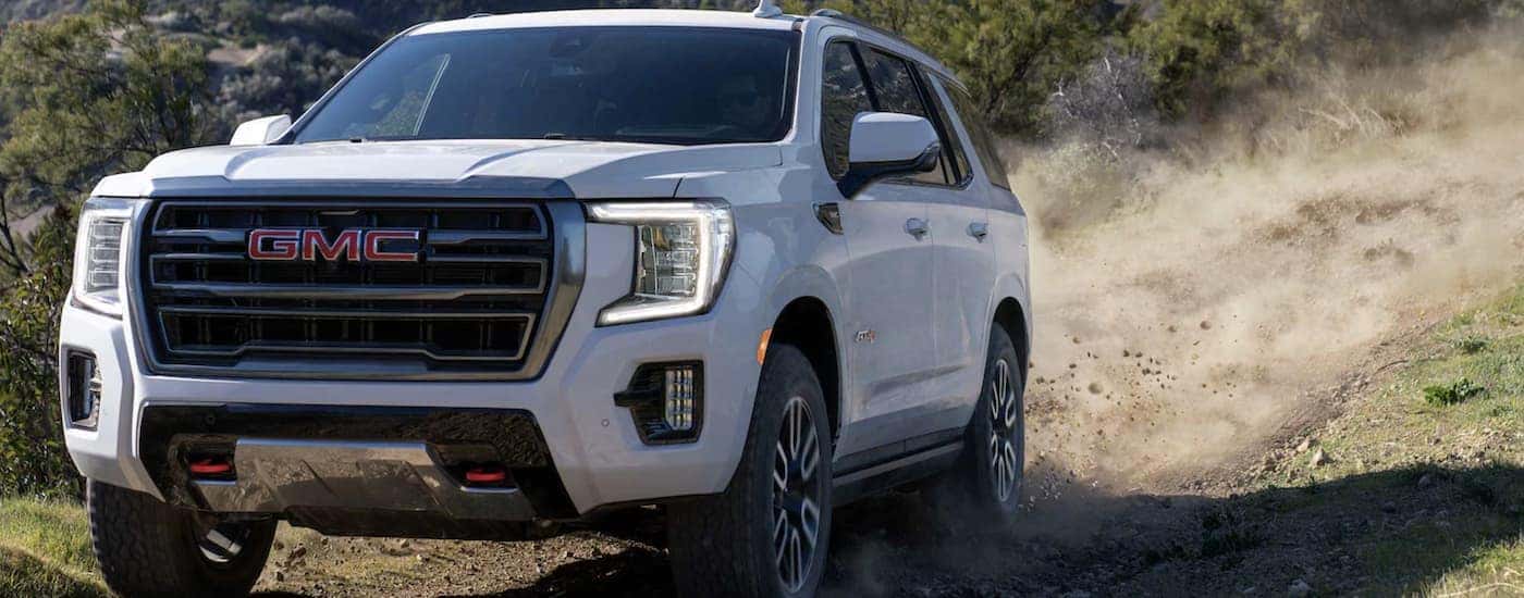 White 2024 GMC Yukon XL driving off-road.