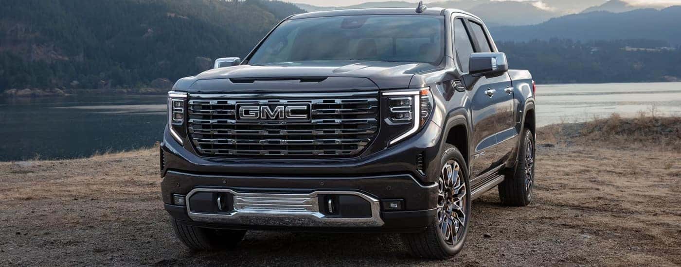 A black 2026 Sierra 1500 Denali for sale parked near a lake.