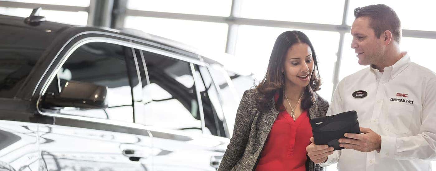 A GMC service advisor discusses scheduled maintenance with a customer.