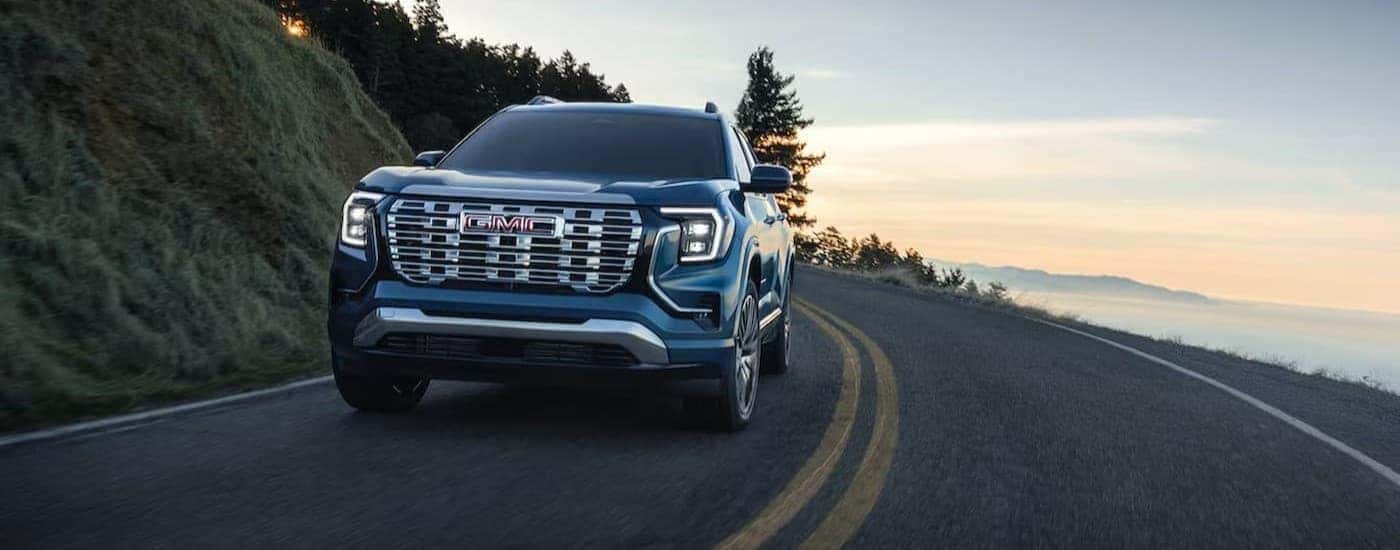 A blue 2026 GMC Terrain driving on a highway.