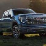 Blue 2026 GMC Sierra 1500 parked on a grassy knoll