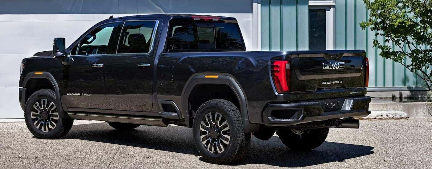 A black 2026 GMC Sierra 3500 Denali parked near a garage.