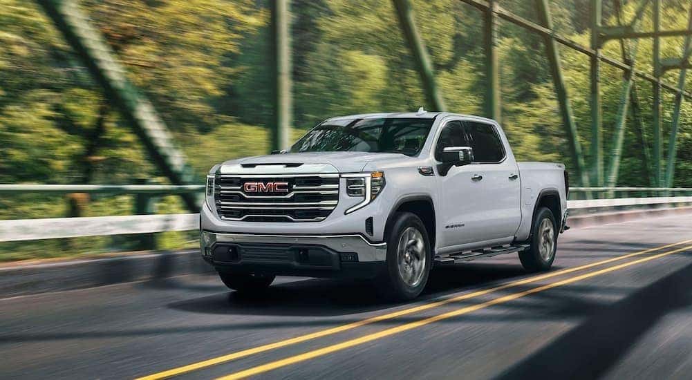 A white 2026 GMC Sierra 1500 for sale in Atlanta driving on a bridge.